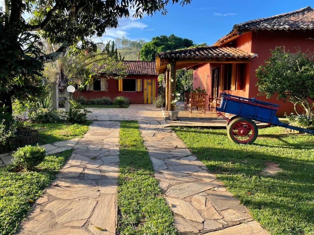 Caminho de pedra pelo jardim até as casas vermelhas